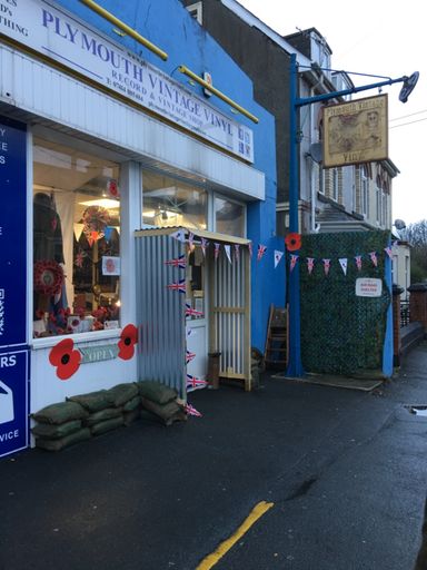 The Plymouth Vintage Vinyl shopfront on Moorland Road dressed for Remembrance Day with poppies, Union Jack and sandbag trench